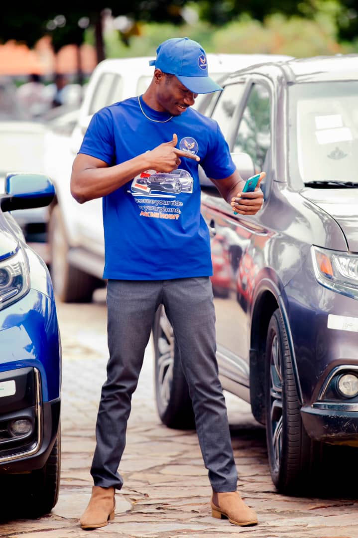 Boasiako ambassador demonstrating phone based vehicle security beside a car